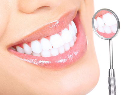 Woman smiling, exposing teeth to small dental mirror